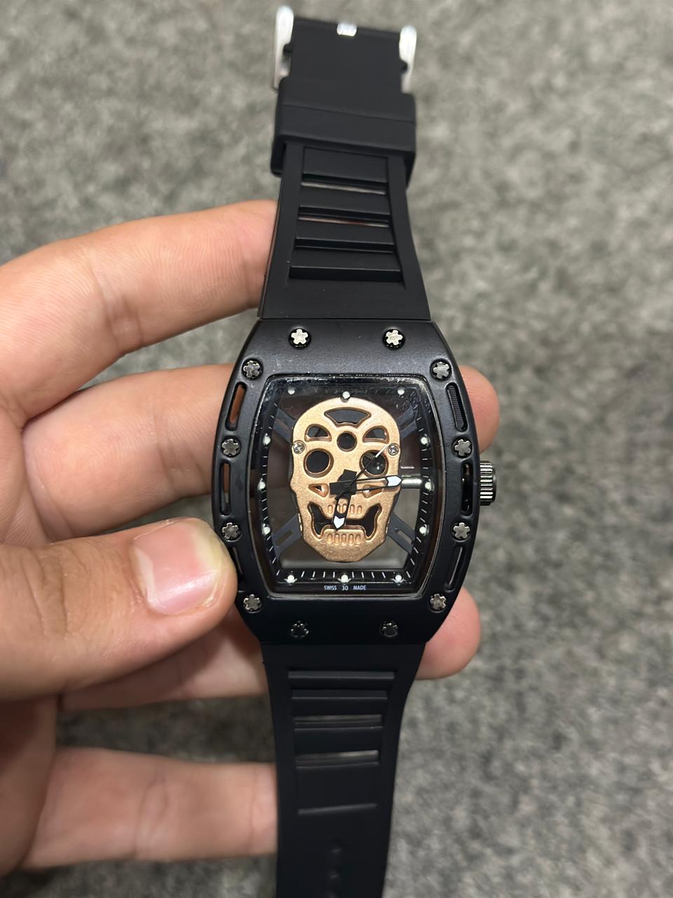 High-end black wristwatch featuring bronze skull motif on dial